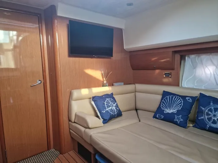  Yacht Photos Pics Interior of 2008 Jeanneau Prestige 38 S yacht with beige seating and nautical-themed pillows.