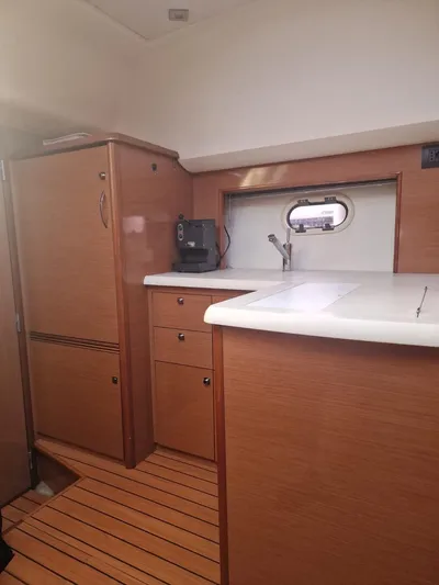  Yacht Photos Pics 2008 Jeanneau Prestige 38 S yacht interior with wooden cabinetry and compact kitchen area.