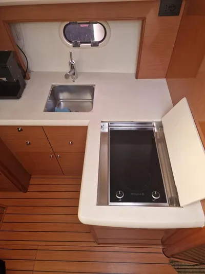  Yacht Photos Pics 2008 Jeanneau Prestige 38 S yacht kitchen with sink and stove, wooden flooring.