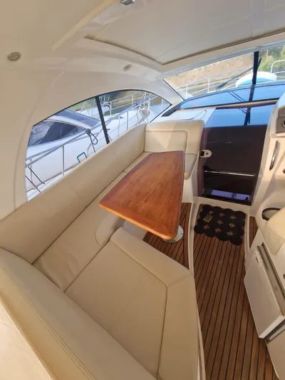  Yacht Photos Pics Interior of 2008 Jeanneau Prestige 38 S. yacht with beige seating and wooden table.