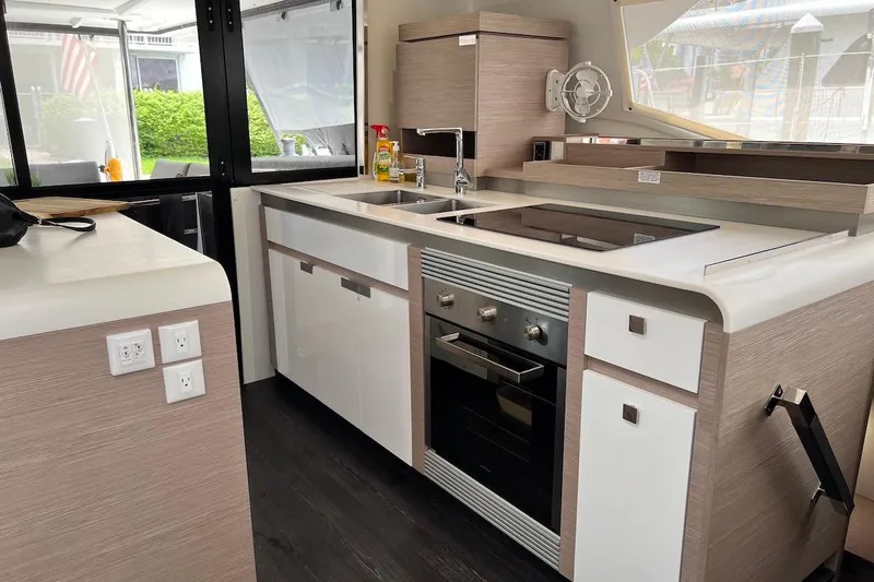Amajen Yacht Photos Pics Modern kitchen interior of 2022 Fountaine Pajot Aura 51 yacht, featuring sleek design and appliances.