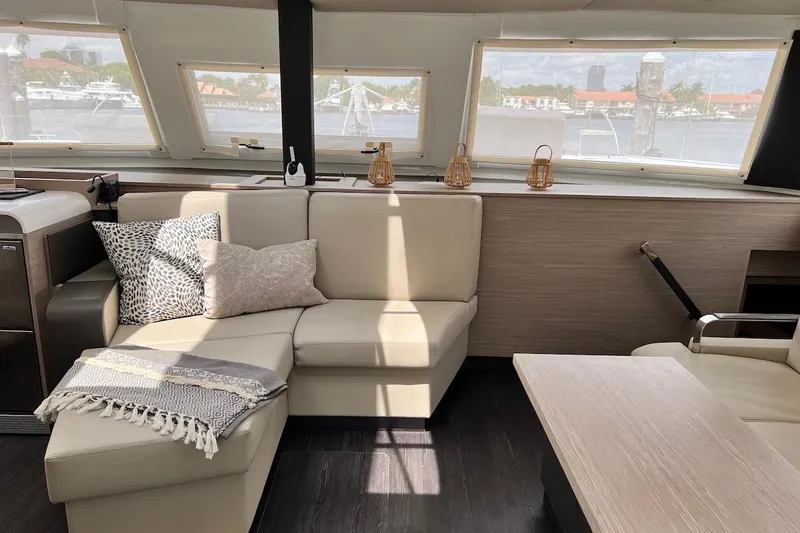 Amajen Yacht Photos Pics Luxurious interior of 2022 Fountaine Pajot Aura 51 catamaran with elegant seating and decor.