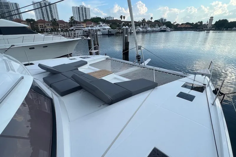 Amajen Yacht Photos Pics 2022 Fountaine Pajot Aura 51 catamaran docked at marina with cityscape background.
