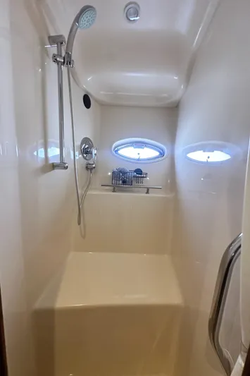 Bad Kitty Yacht Photos Pics Shower area in 2007 Sea Ray 380 Sundancer yacht with oval windows and modern fixtures.
