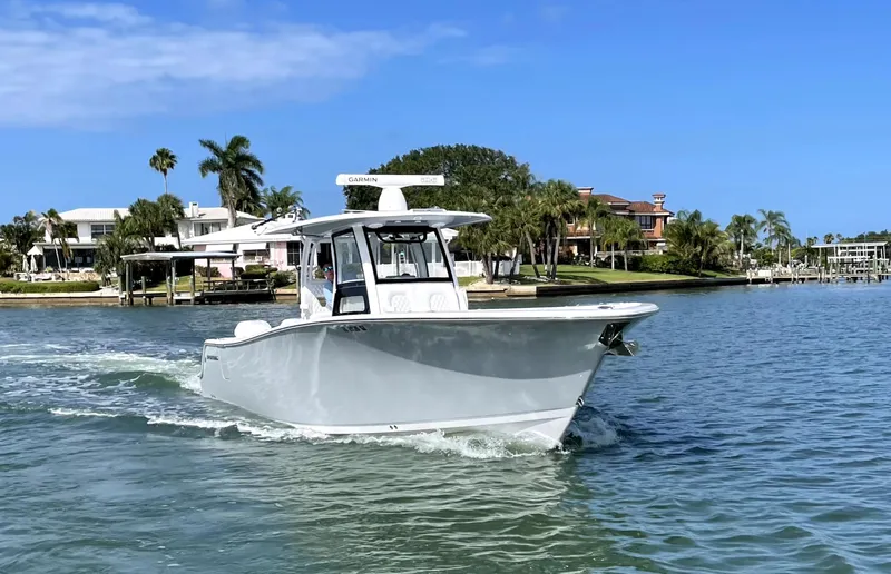  Yacht Photos Pics 2021 Sportsman Open 322 Center Console boat cruising near waterfront homes.