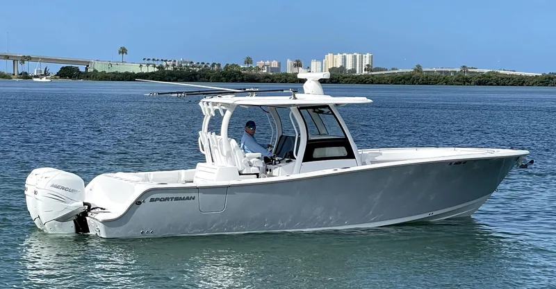  Yacht Photos Pics 2021 Sportsman Open 322 Center Console boat on calm water, cityscape in background.