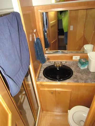  Yacht Photos Pics Bathroom interior of a 1998 Navigator 53 yacht with wood cabinetry and black sink.