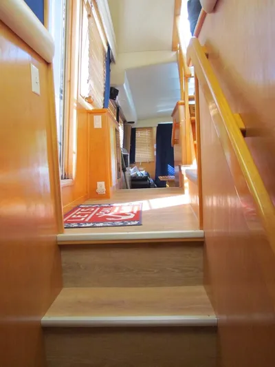  Yacht Photos Pics Interior stairs of a 1998 Navigator 53 yacht with wooden finish and natural lighting.