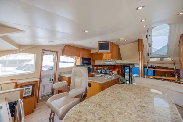 Volare Yacht Photos Pics Luxurious interior of 2006 Hatteras 64 Motor Yacht with modern kitchen and seating area.