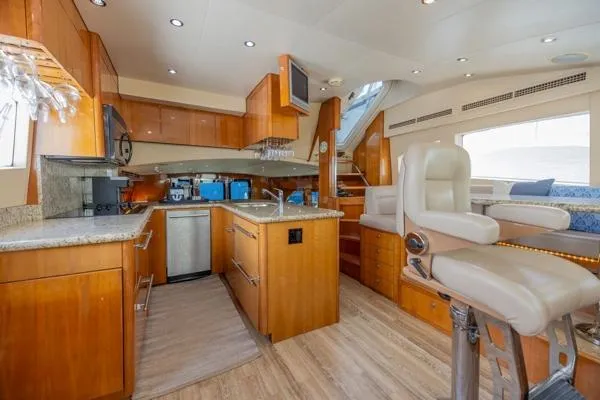 Volare Yacht Photos Pics Luxurious interior of 2006 Hatteras 64 Motor Yacht with modern kitchen and seating area.