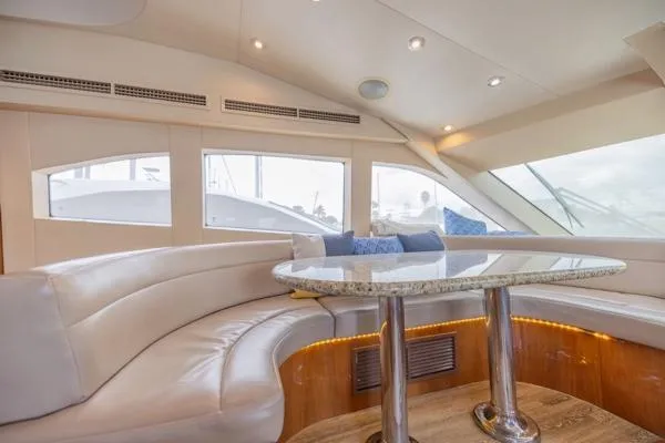 Volare Yacht Photos Pics Luxurious interior of 2006 Hatteras 64 Motor Yacht with plush seating and elegant table.
