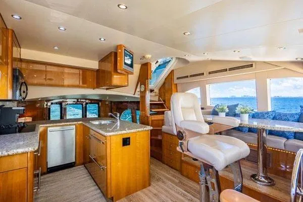Volare Yacht Photos Pics Luxurious interior of 2006 Hatteras 64 Motor Yacht with modern kitchen and ocean view.
