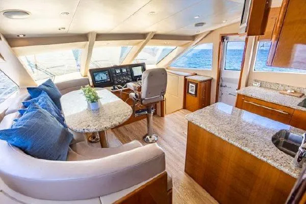 Volare Yacht Photos Pics Luxurious interior of 2006 Hatteras 64 Motor Yacht with plush seating and modern helm.