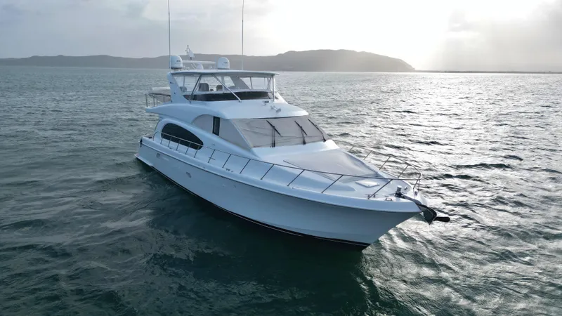 Volare Yacht Photos Pics 2006 Hatteras 64 Motor Yacht cruising on open water at sunset.