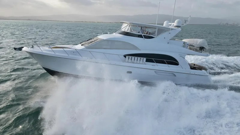 Volare Yacht Photos Pics 2006 Hatteras 64 Motor Yacht cruising on open water, creating a dynamic splash.