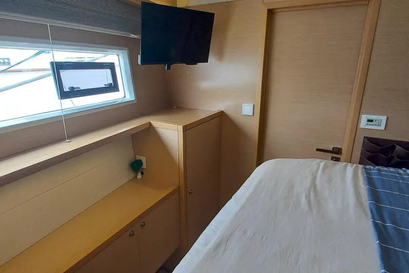 Amea Yacht Photos Pics Interior cabin of 2014 Lagoon 52 F yacht with window, TV, and bed.