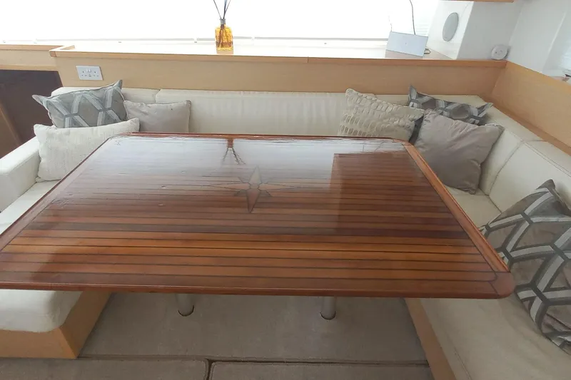 Amea Yacht Photos Pics Luxurious interior of 2014 Lagoon 52 F yacht with polished wooden table and plush cushions.