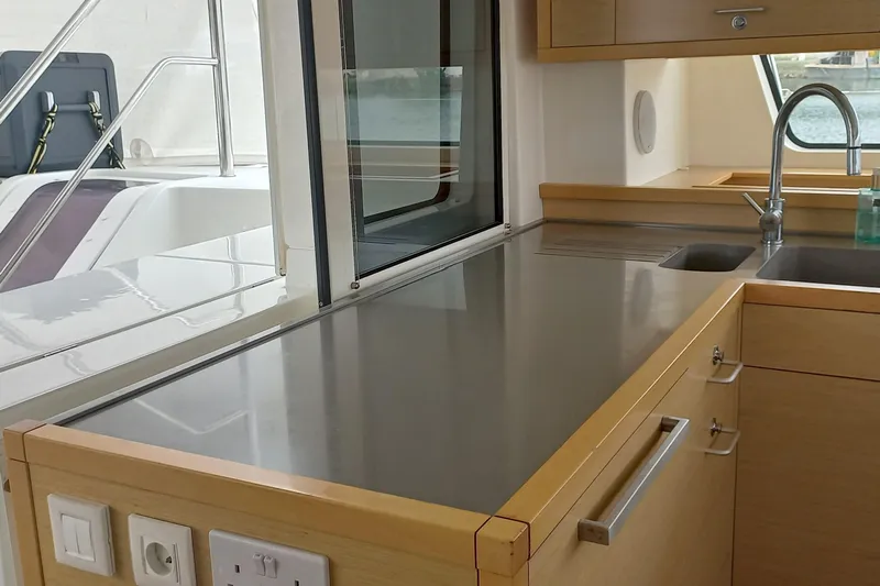 Amea Yacht Photos Pics Modern kitchen area on a 2014 Lagoon 52 F yacht, featuring sleek countertops and cabinetry.