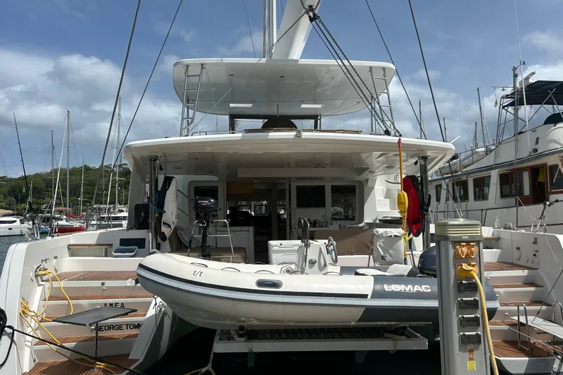 Amea Yacht Photos Pics 2014 Lagoon 52 F yacht docked with inflatable boat, marina background.