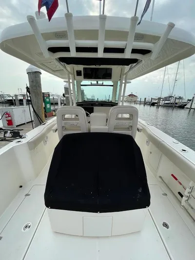  Yacht Photos Pics 2019 Boston Whaler 330 Outrage boat interior at marina, showcasing seating and helm.