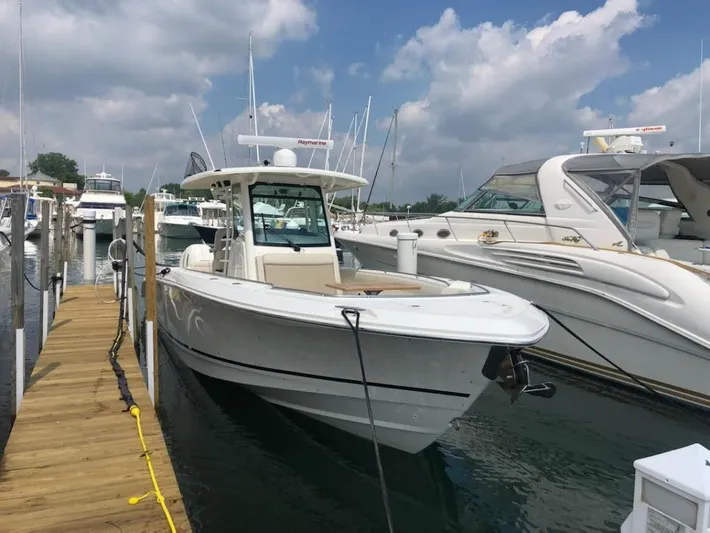 Yacht Photos Pics 2019 Boston Whaler 330 Outrage docked at marina under cloudy sky.