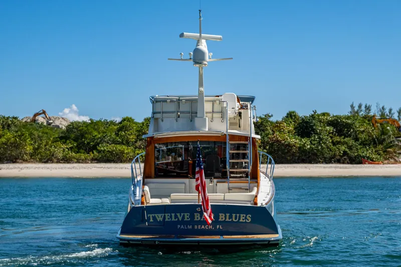 Twelve Bar Blues Yacht Photos Pics 2019 Hinckley Talaria 43 Flybridge yacht on water, rear view, with American flag.