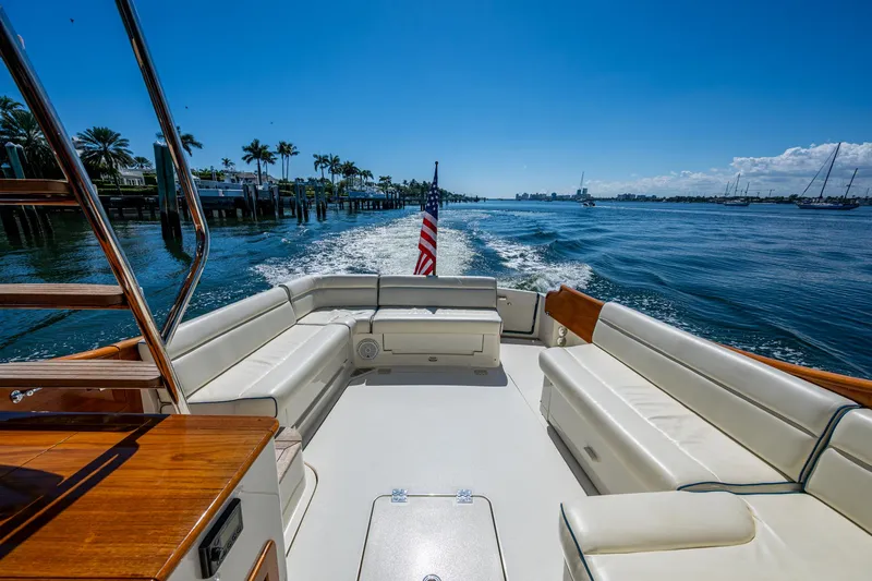 Twelve Bar Blues Yacht Photos Pics Hinckley Talaria 43 Flybridge 2019 yacht cruising on a sunny day with palm trees in the background.