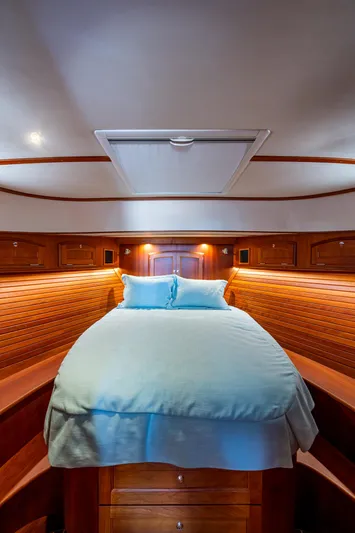 Twelve Bar Blues Yacht Photos Pics 2019 Hinckley Talaria 43 Flybridge cabin with cozy bed and elegant wood paneling.