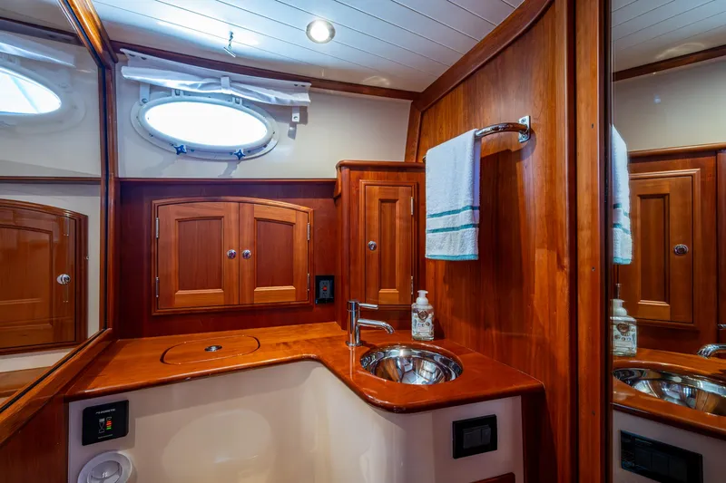 Twelve Bar Blues Yacht Photos Pics Luxurious 2019 Hinckley Talaria 43 Flybridge bathroom with wood cabinetry and stainless steel sink.