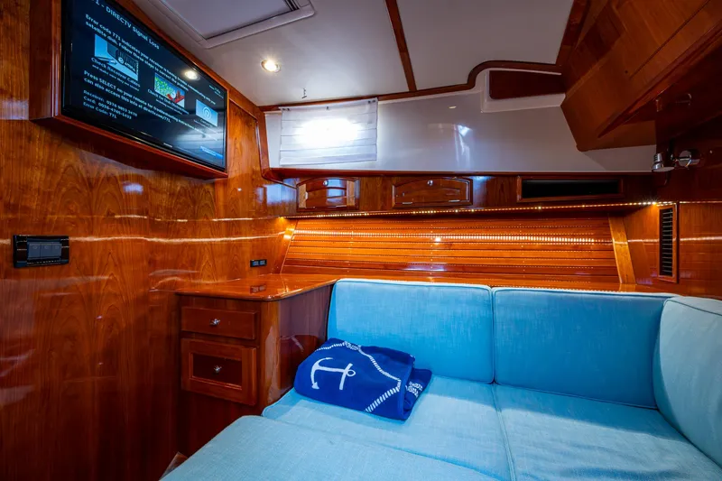 Twelve Bar Blues Yacht Photos Pics Luxurious interior of 2019 Hinckley Talaria 43 Flybridge with wood paneling and blue seating.