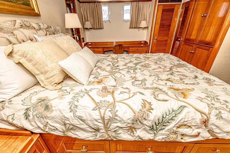 Diday Yacht Photos Pics Luxurious yacht bedroom with floral bedding, wooden furnishings, and soft lighting, 1984 Burger model.