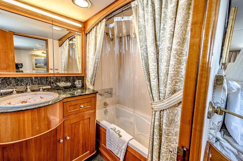 Diday Yacht Photos Pics Luxurious yacht bathroom with wood cabinetry, marble countertop, and elegant shower curtains.
