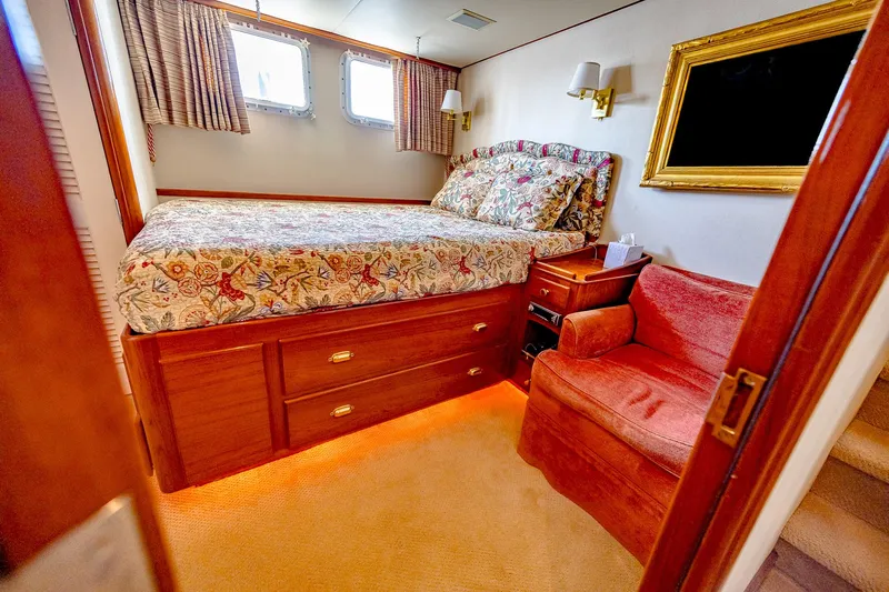 Diday Yacht Photos Pics Cozy bedroom in 1984 Burger 91 yacht with floral bedding and warm lighting.