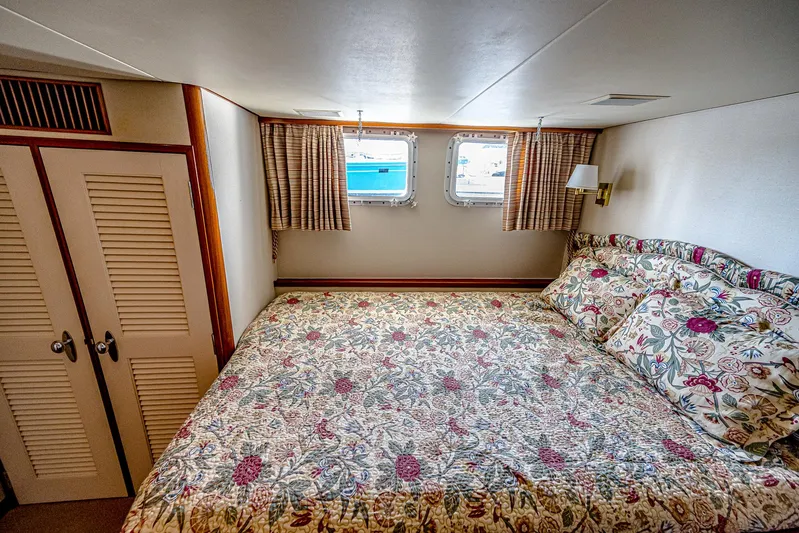 Diday Yacht Photos Pics Cozy bedroom in 1984 Burger 91 yacht with floral bedding and porthole windows.