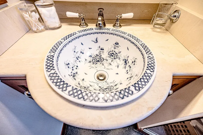 Diday Yacht Photos Pics Elegant bathroom sink with floral design, set in a marble countertop.