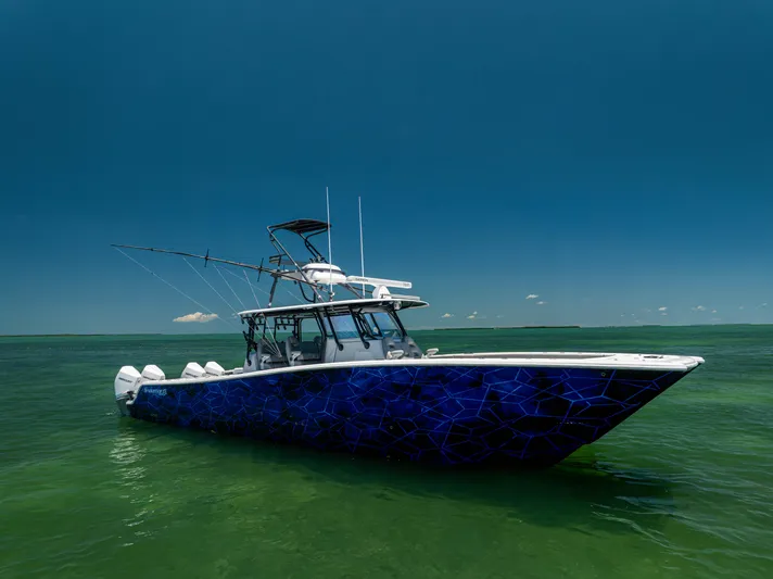  Yacht Photos Pics Freeman 42 LR 2021 boat with blue geometric design on calm green water.