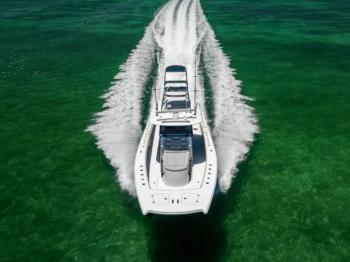  Yacht Photos Pics Aerial view of 2021 Freeman 42 LR boat cruising on clear green water.