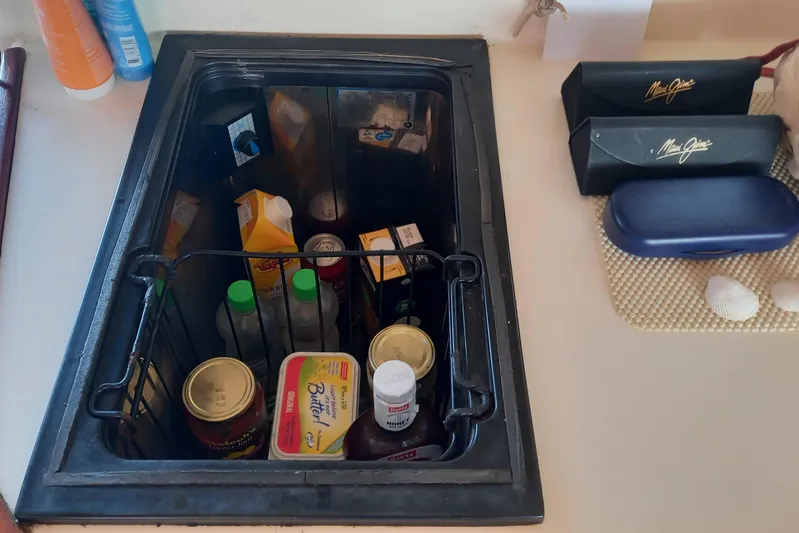 Dreamteam Yacht Photos Pics Built-in fridge on 1993 Fountaine Pajot Antigua 37 yacht, stocked with various food items.