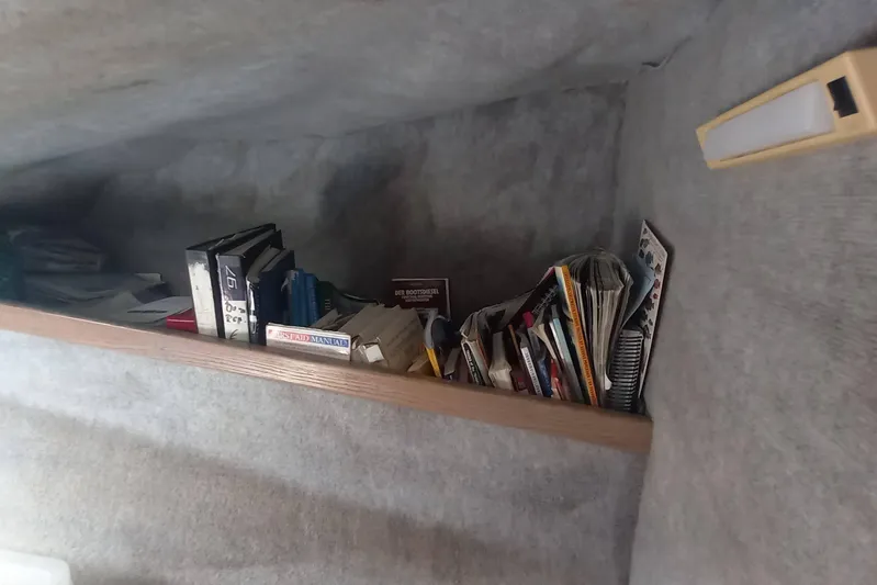 Dreamteam Yacht Photos Pics Books and manuals on a shelf inside a 1993 Fountaine Pajot Antigua 37 yacht.