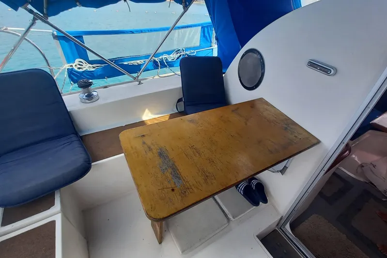 Dreamteam Yacht Photos Pics 1993 Fountaine Pajot Antigua 37 yacht interior with wooden table and blue seating.