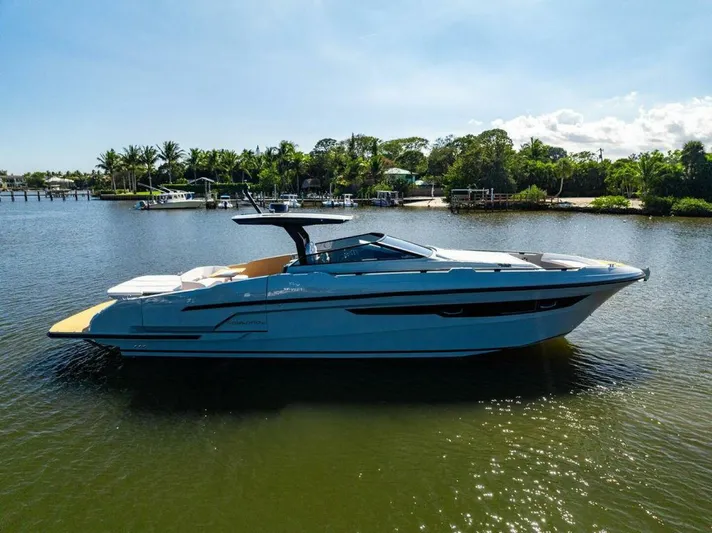  Yacht Photos Pics 2024 Rio Yachts Daytona 50 cruising on a serene river under a clear blue sky.