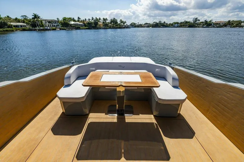  Yacht Photos Pics 2024 Rio Yachts Daytona 50 deck with seating and table, overlooking serene water.