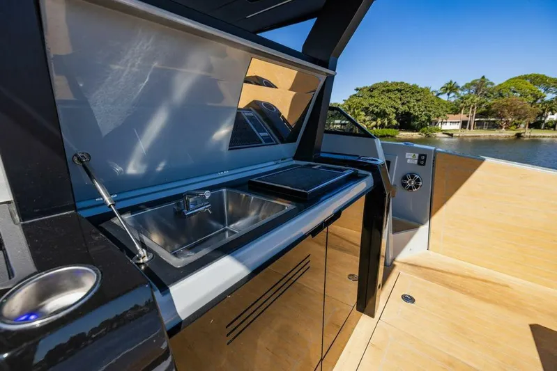  Yacht Photos Pics Outdoor kitchen on 2024 Rio Yachts Daytona 50, featuring sink and grill, with scenic water view.