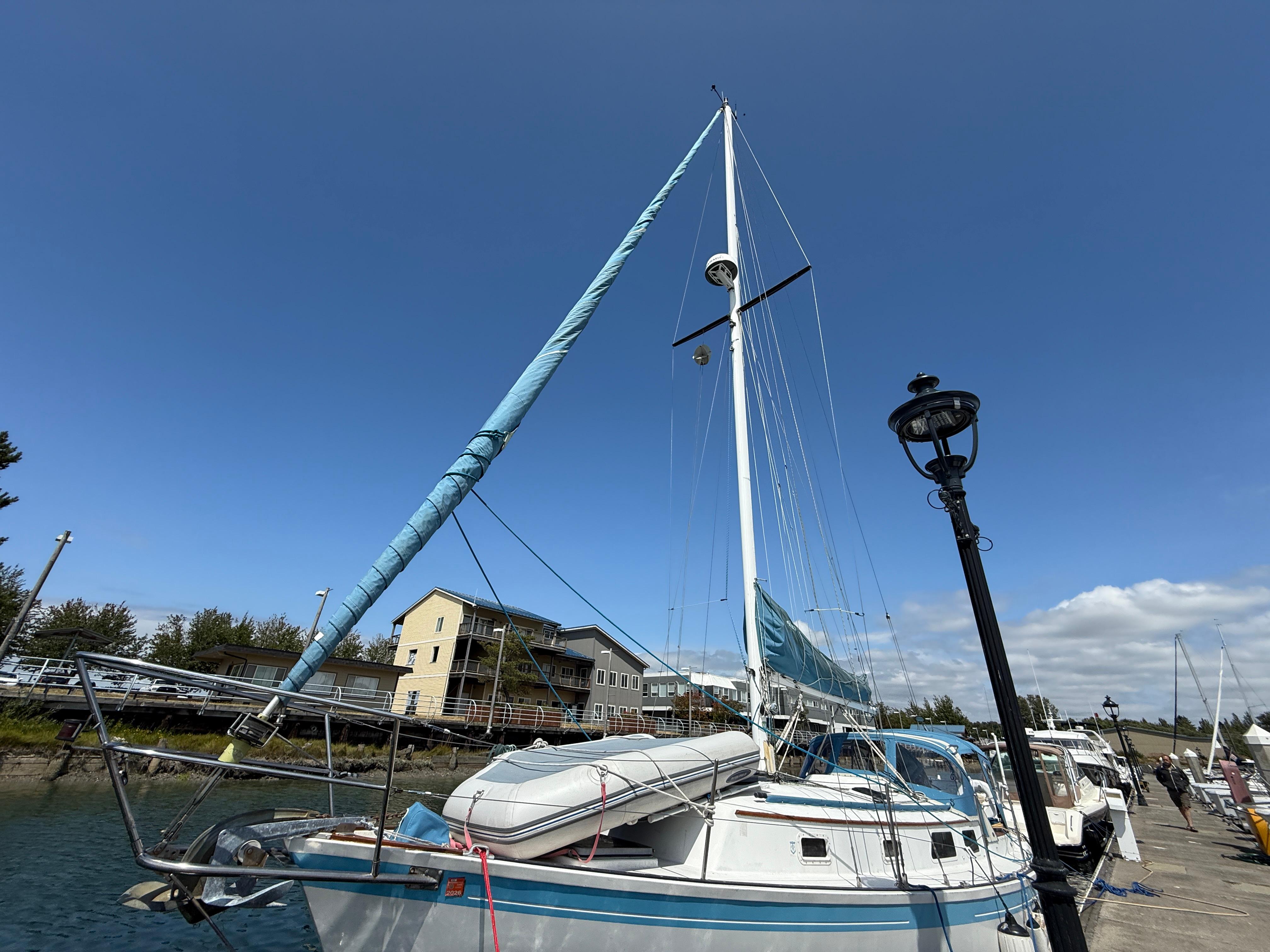 1984 Aloha 32 sailboat docked under clear blue sky.