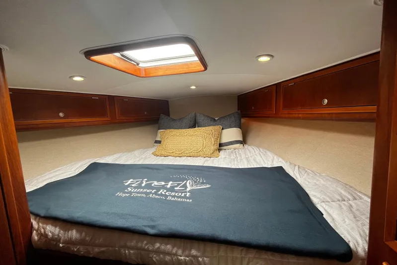  Yacht Photos Pics Cozy cabin interior of 2010 Scopinich 35 EXPRESS with bed and wooden storage cabinets.