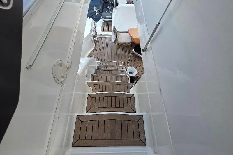 Blue Bird Yacht Photos Pics Staircase on 2008 Neptunus Flybridge MY yacht with wooden steps and seating area.