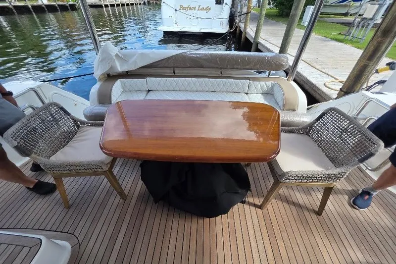 Blue Bird Yacht Photos Pics Luxury seating area on 2008 Neptunus Flybridge MY yacht with wooden table and chairs.