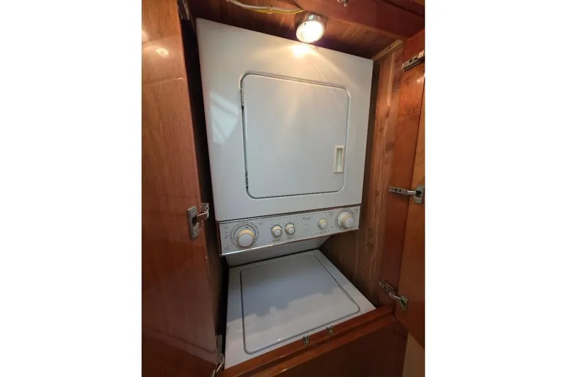 Blue Bird Yacht Photos Pics Stacked washer and dryer in 2008 Neptunus Flybridge MY yacht's wooden cabinet.