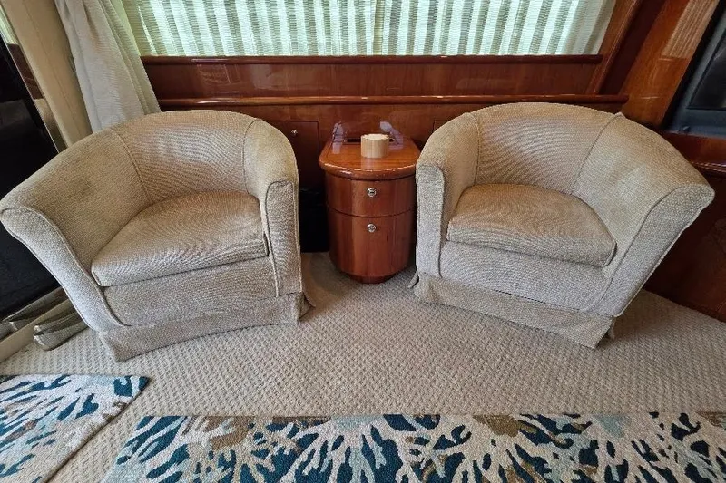 Blue Bird Yacht Photos Pics Luxurious Neptunus Flybridge MY 2008 interior with two beige armchairs and a wooden side table.