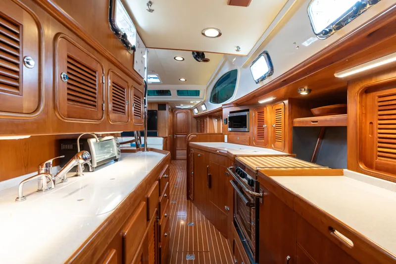 Solitude Yacht Photos Pics Luxurious interior of 2018 Passport Vista 545 Center Cockpit yacht with wooden cabinetry and modern amenities.
